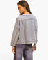 A woman shown from the back wearing a light gray washed denim jacket and matching gray jeans against a plain white studio background.