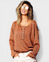 Woman wearing a brown long-sleeve shirt with buttons on a white background
