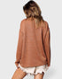 Person wearing a brown sweater and white shorts on a plain background