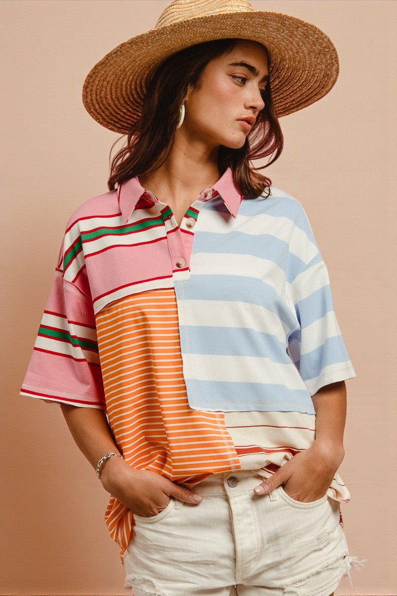 Woman wearing a colorful striped shirt and straw hat on a beige background