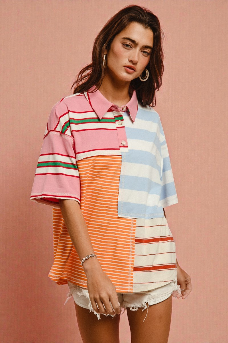 Woman wearing a colorful striped shirt against a pink background