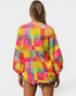 Woman wearing a colorful checkered top on a white background