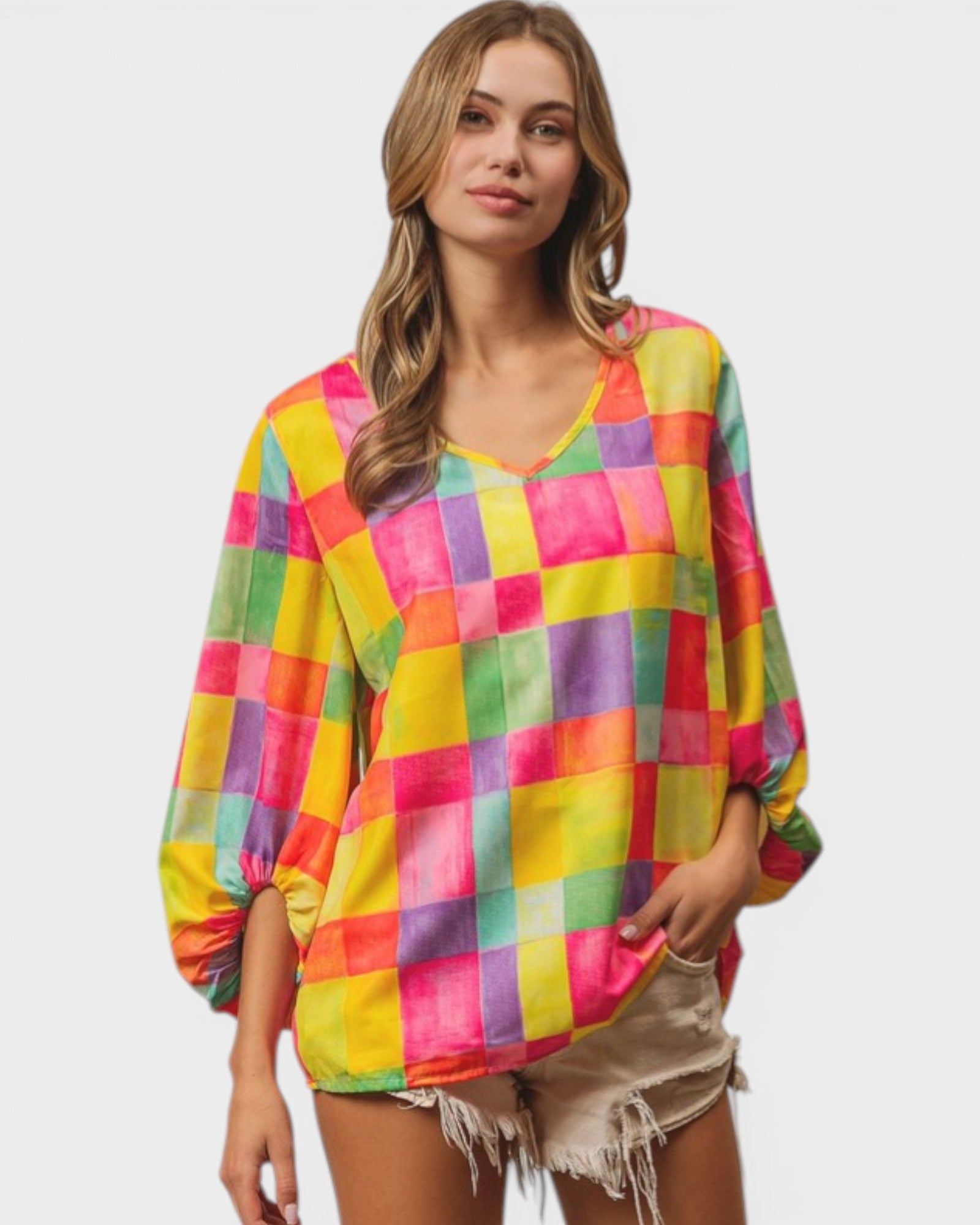 Woman wearing a colorful checkered shirt on a plain background