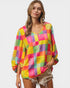 Woman wearing a colorful checkered shirt on a plain background