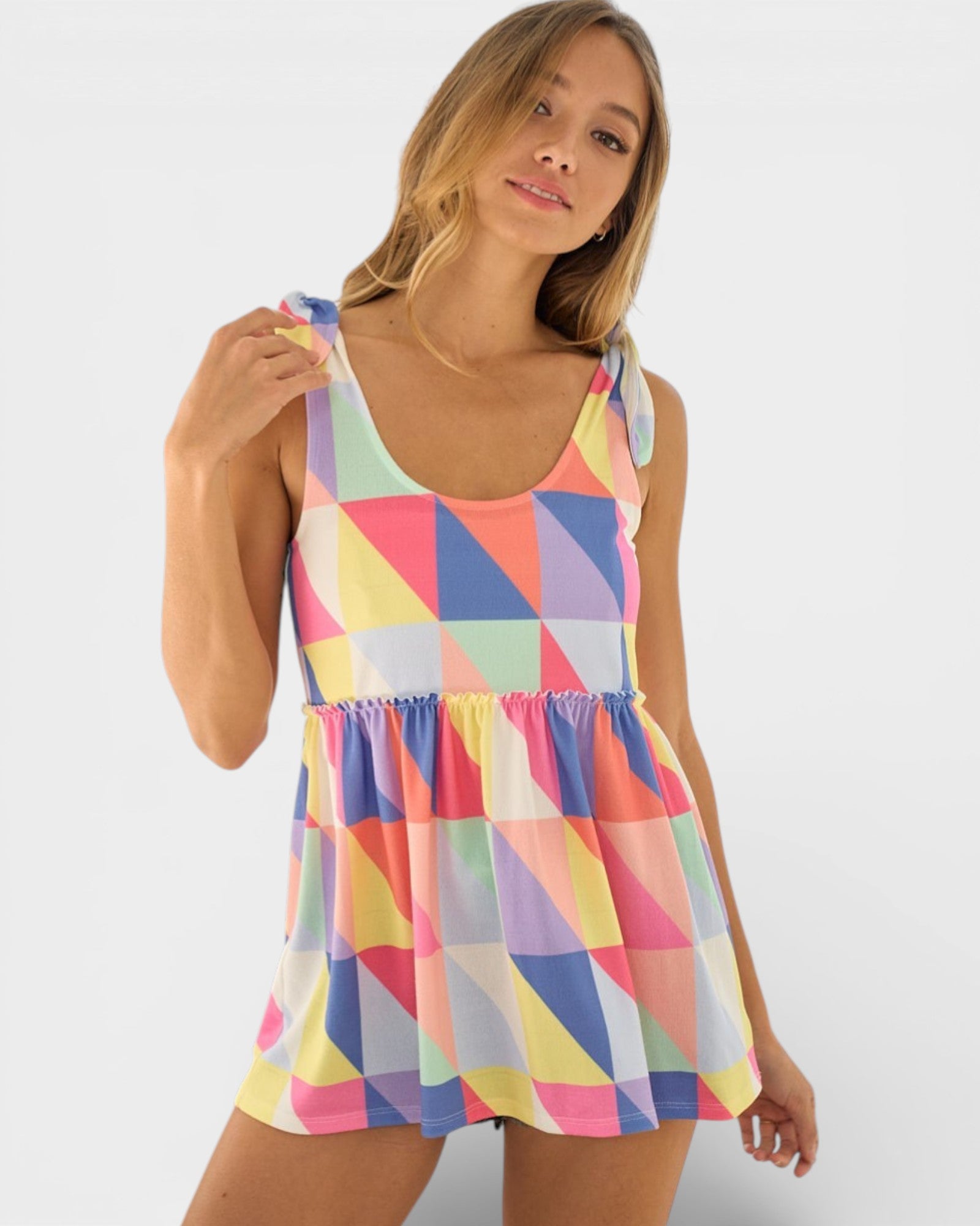 Woman wearing a colorful geometric patterned dress on a white background