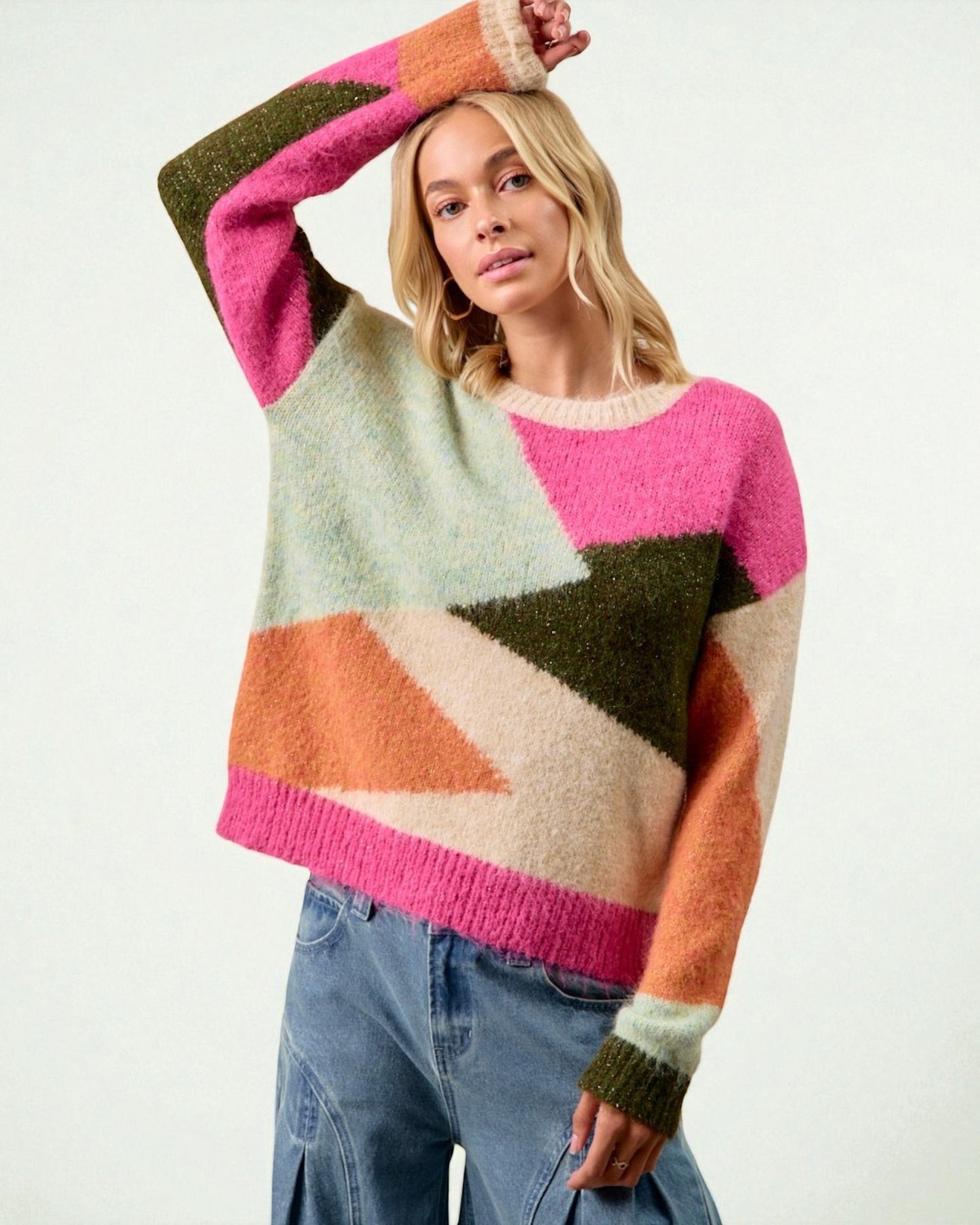 Woman wearing a colorful geometric-patterned sweater on a white background