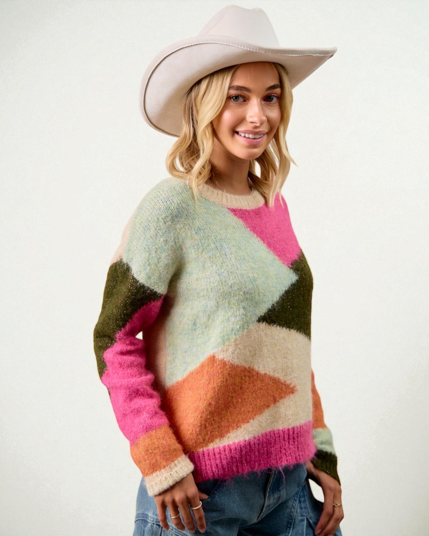 Woman wearing a colorful sweater and cowboy hat on a white background