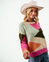 Woman wearing a colorful sweater and cowboy hat on a white background