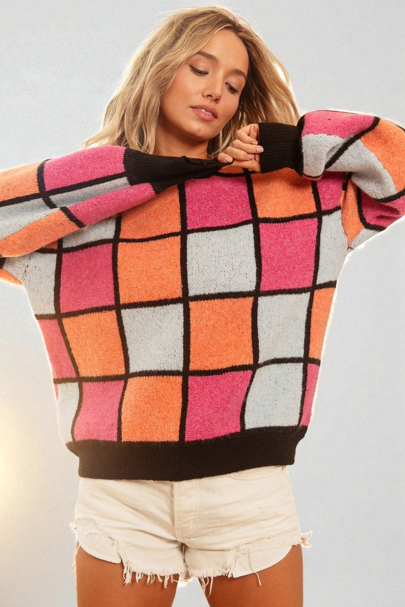 Person wearing a colorful checkered sweater with a plain background
