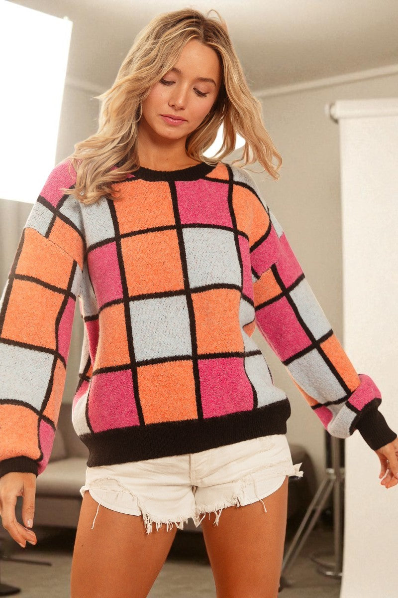 Woman wearing a colorful checkered sweater in an indoor setting