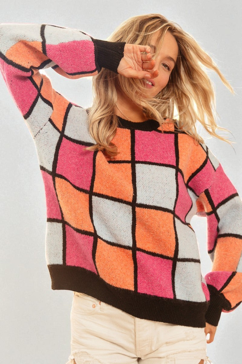 Person wearing a colorful checkered sweater on a plain background