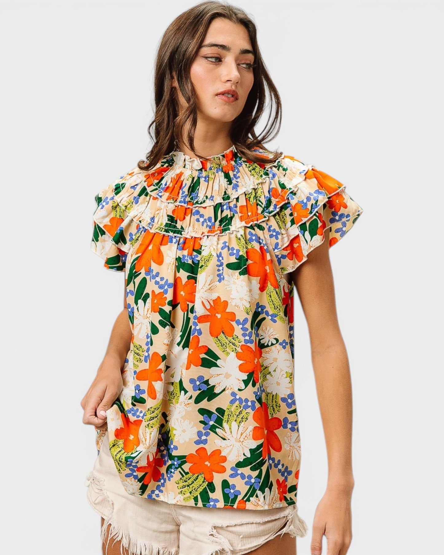 Woman wearing a colorful floral blouse against a plain background