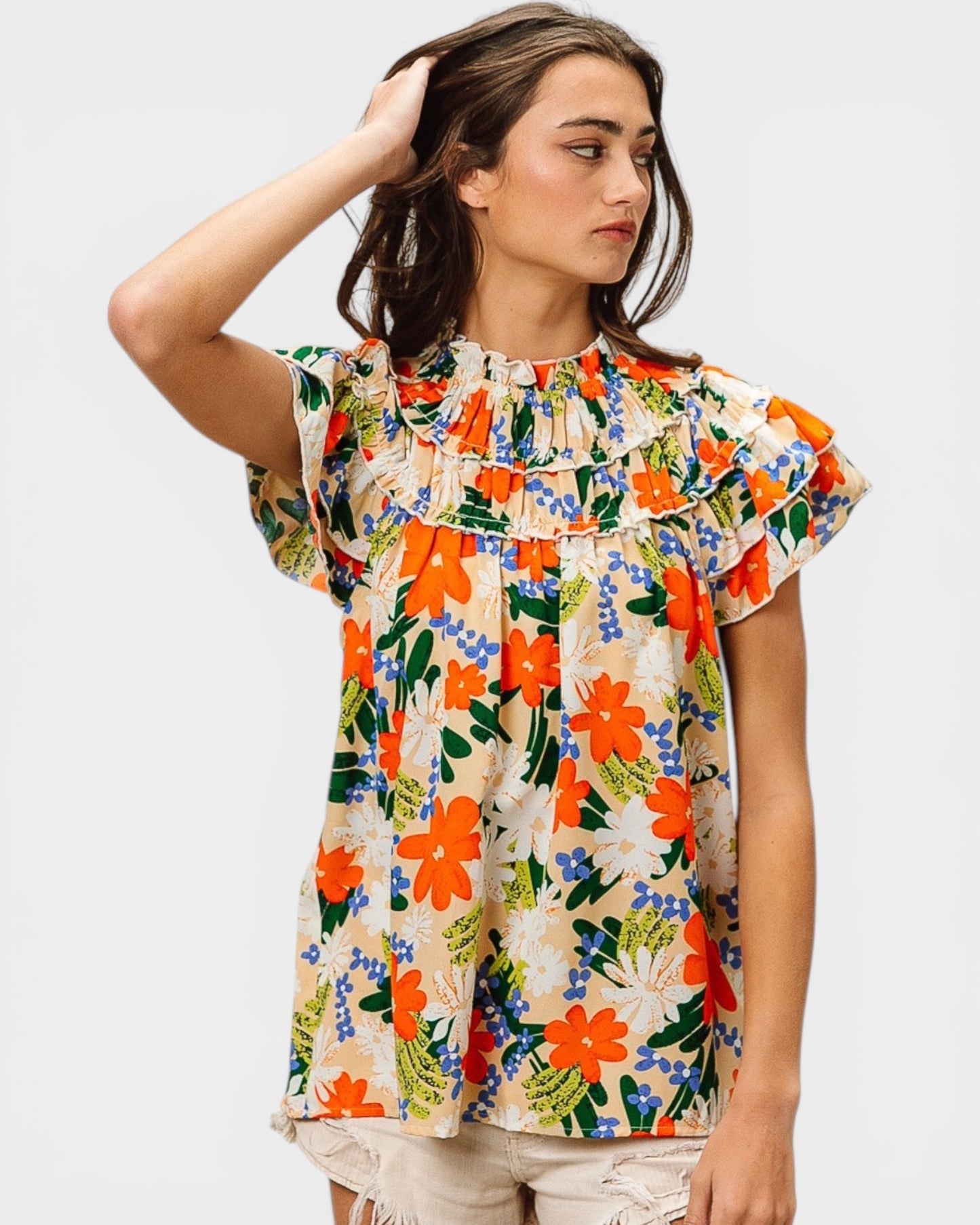 Woman wearing a colorful floral blouse against a white background