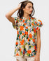 Woman wearing a colorful floral blouse against a white background