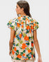 Woman wearing a colorful floral blouse on a plain background