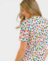 Woman wearing a colorful leopard print top on a white background