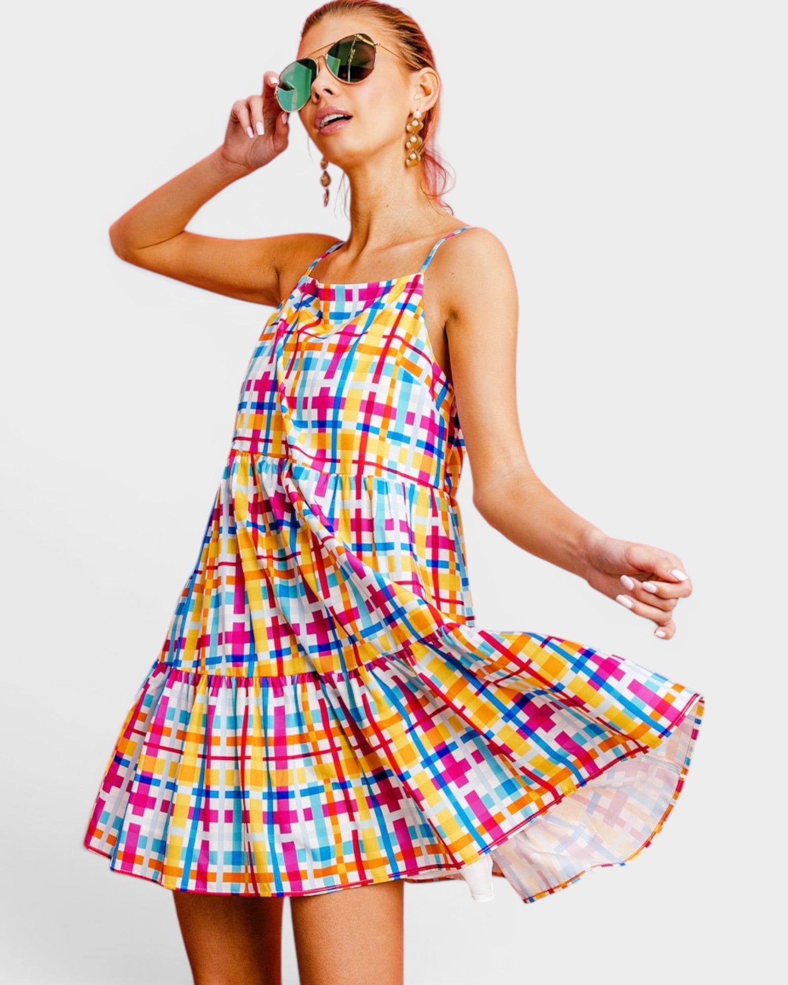 Woman wearing a colorful plaid dress against a white background