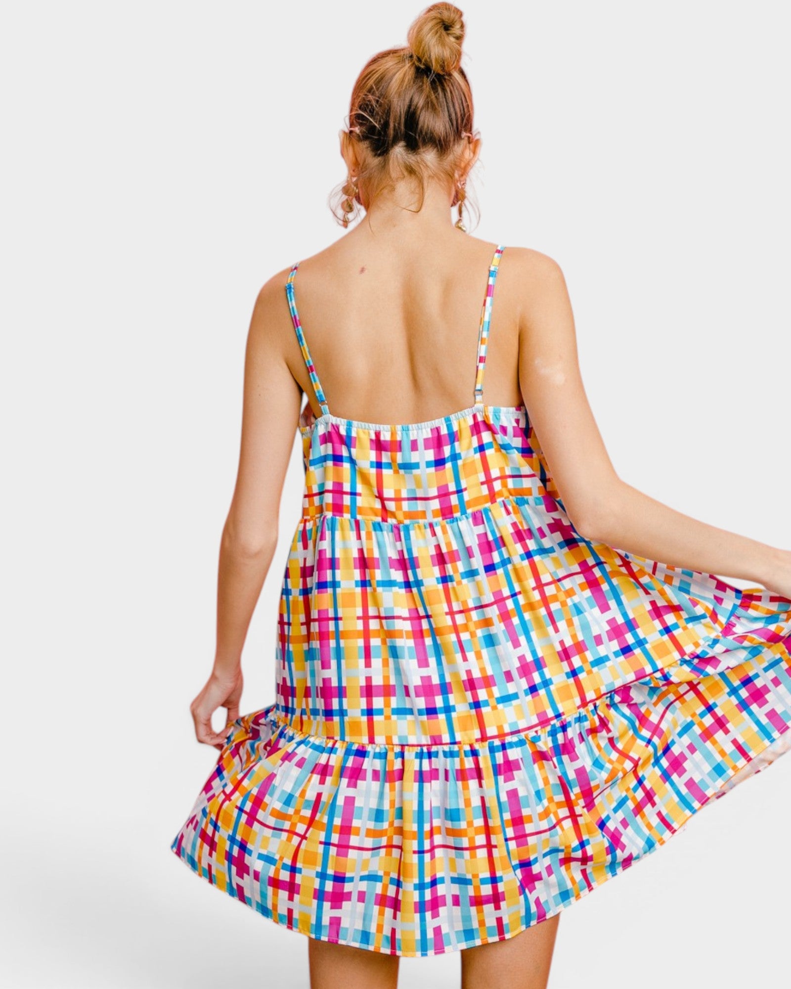 Woman wearing a colorful plaid dress on a white background