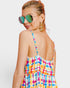Woman wearing a colorful plaid dress with a plain background
