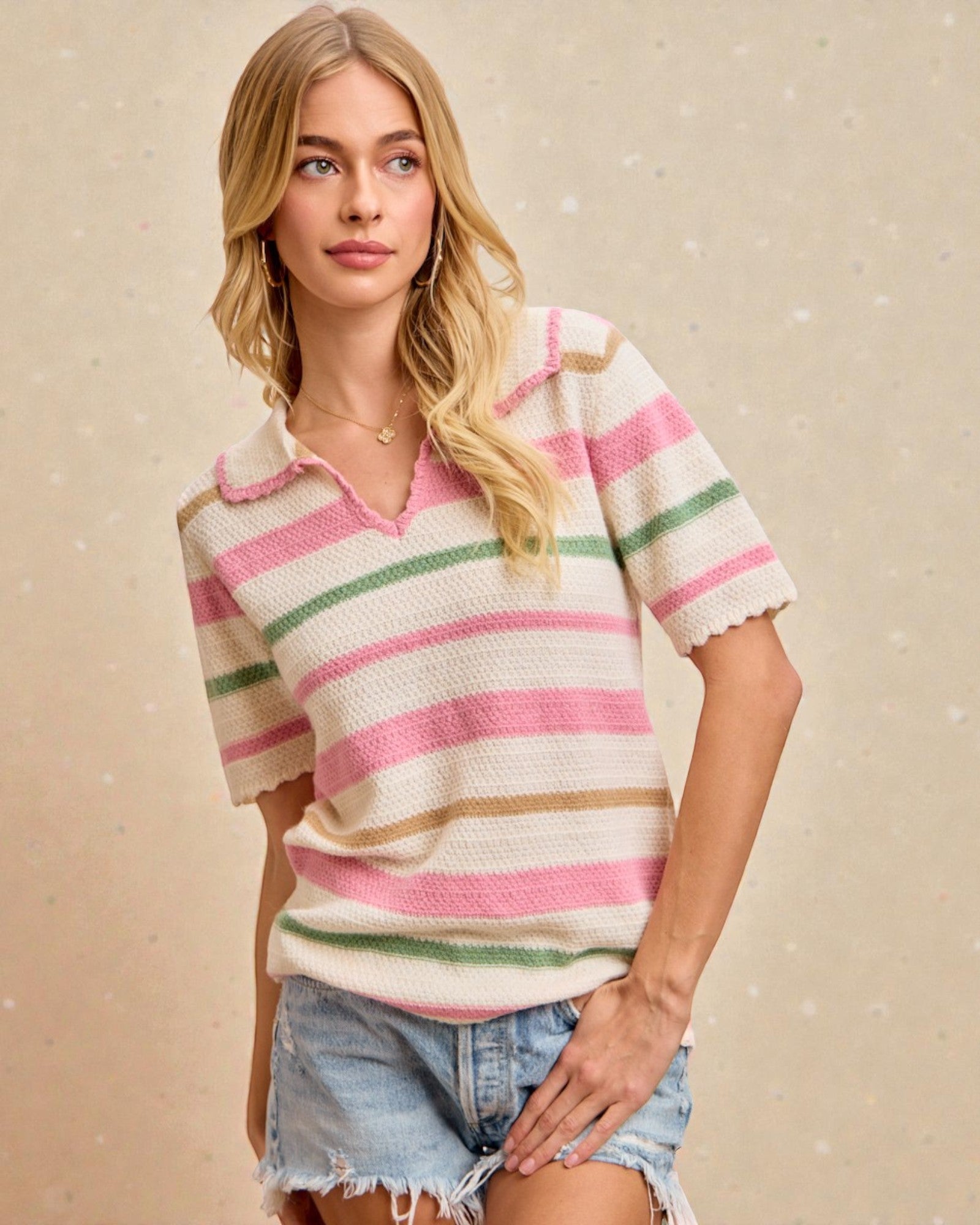 Woman wearing a striped shirt and denim shorts against a beige background