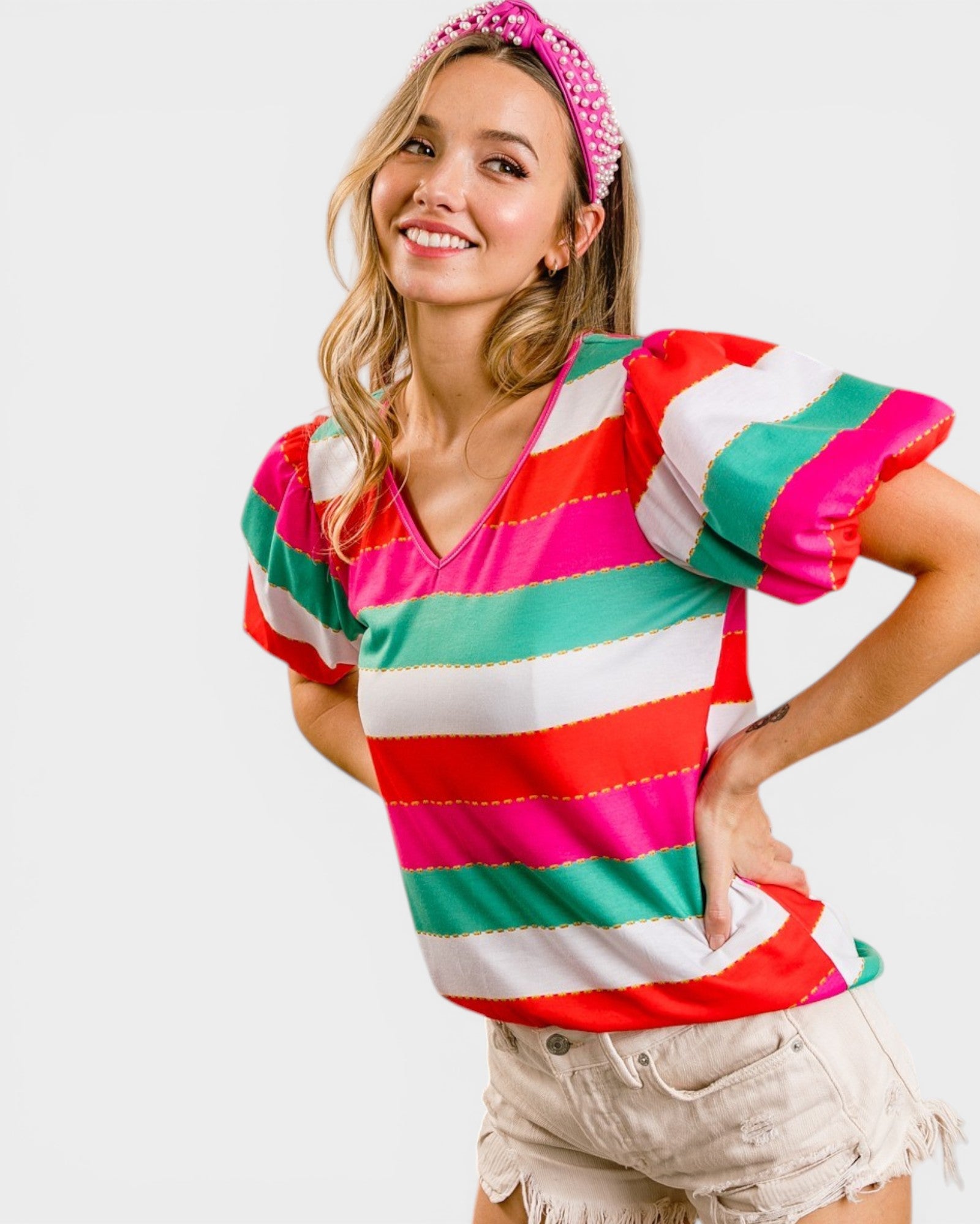 Woman wearing a colorful striped shirt with a plain background