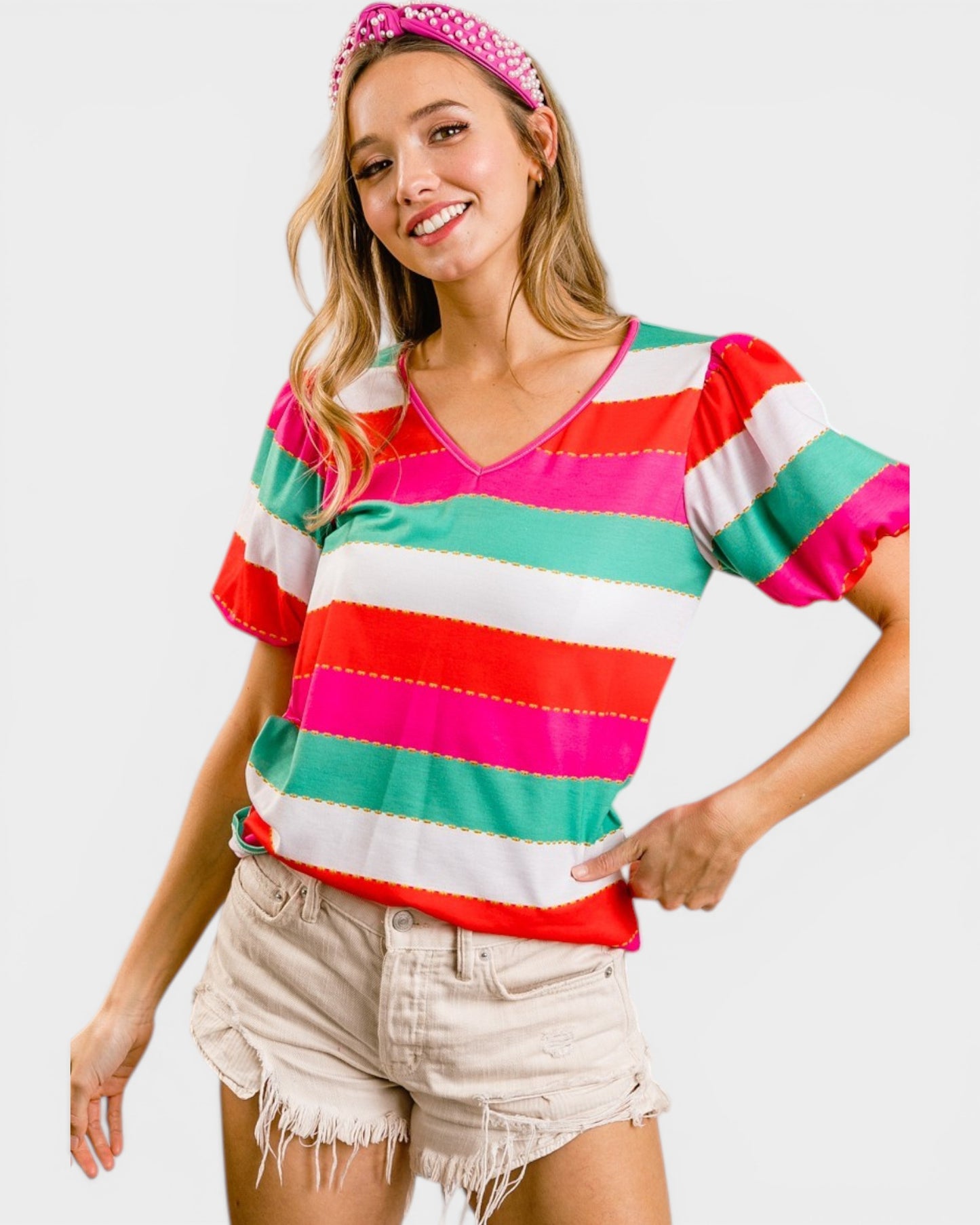 Woman wearing a colorful striped shirt and shorts on a white background