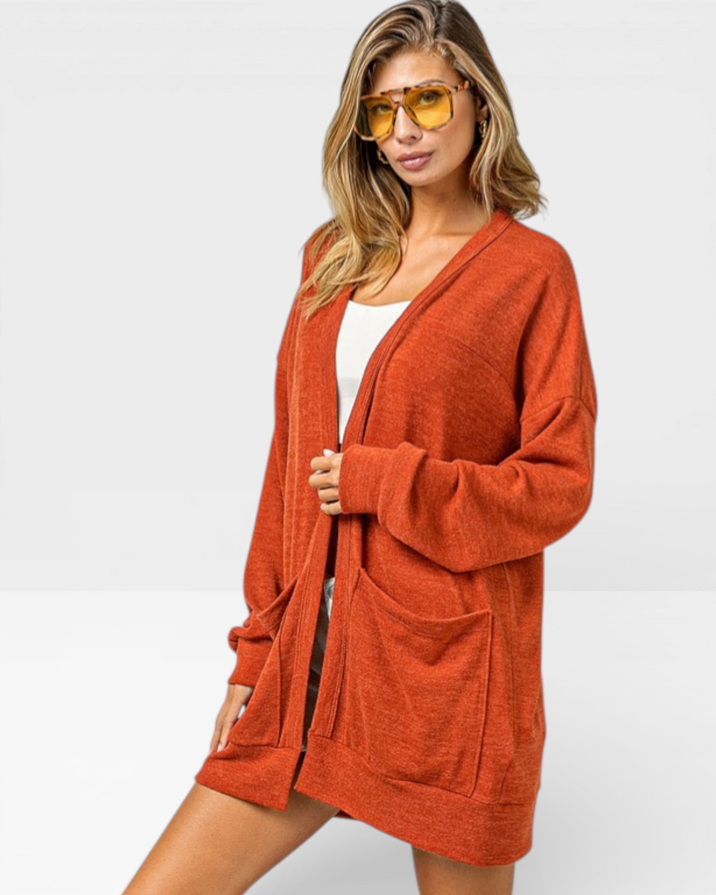 Woman wearing a rust-colored cardigan on a white background