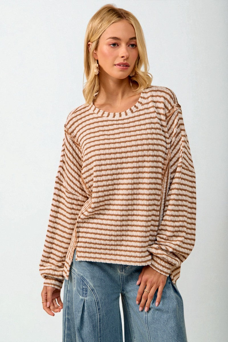 Woman wearing a striped sweater and jeans on a white background