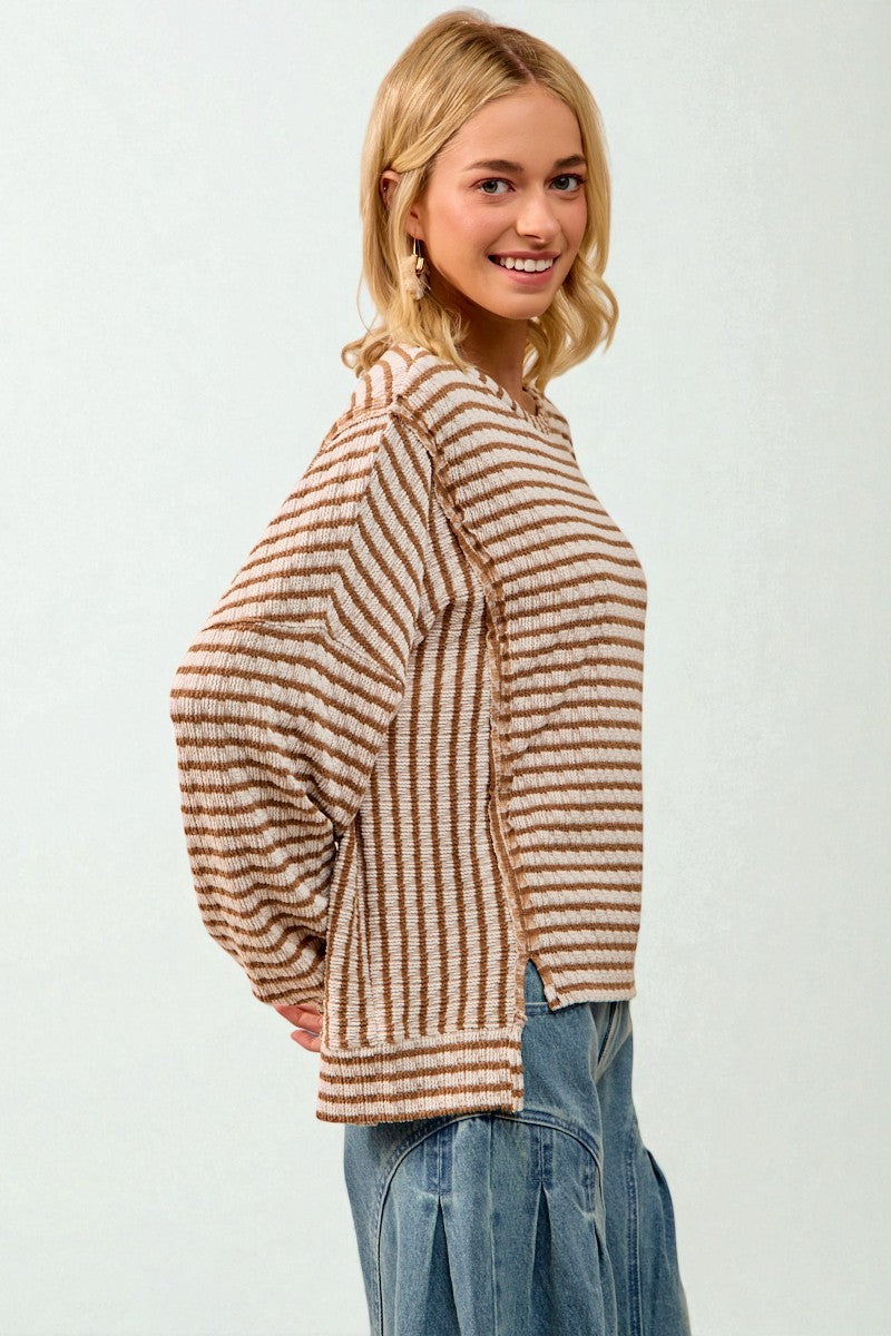 Woman wearing a striped sweater and jeans on a white background