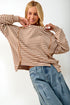Woman wearing a striped sweater and jeans on a white background