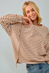 Woman wearing a striped sweater and jeans against a plain background