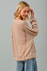 Woman wearing a striped sweater and jeans against a gray background