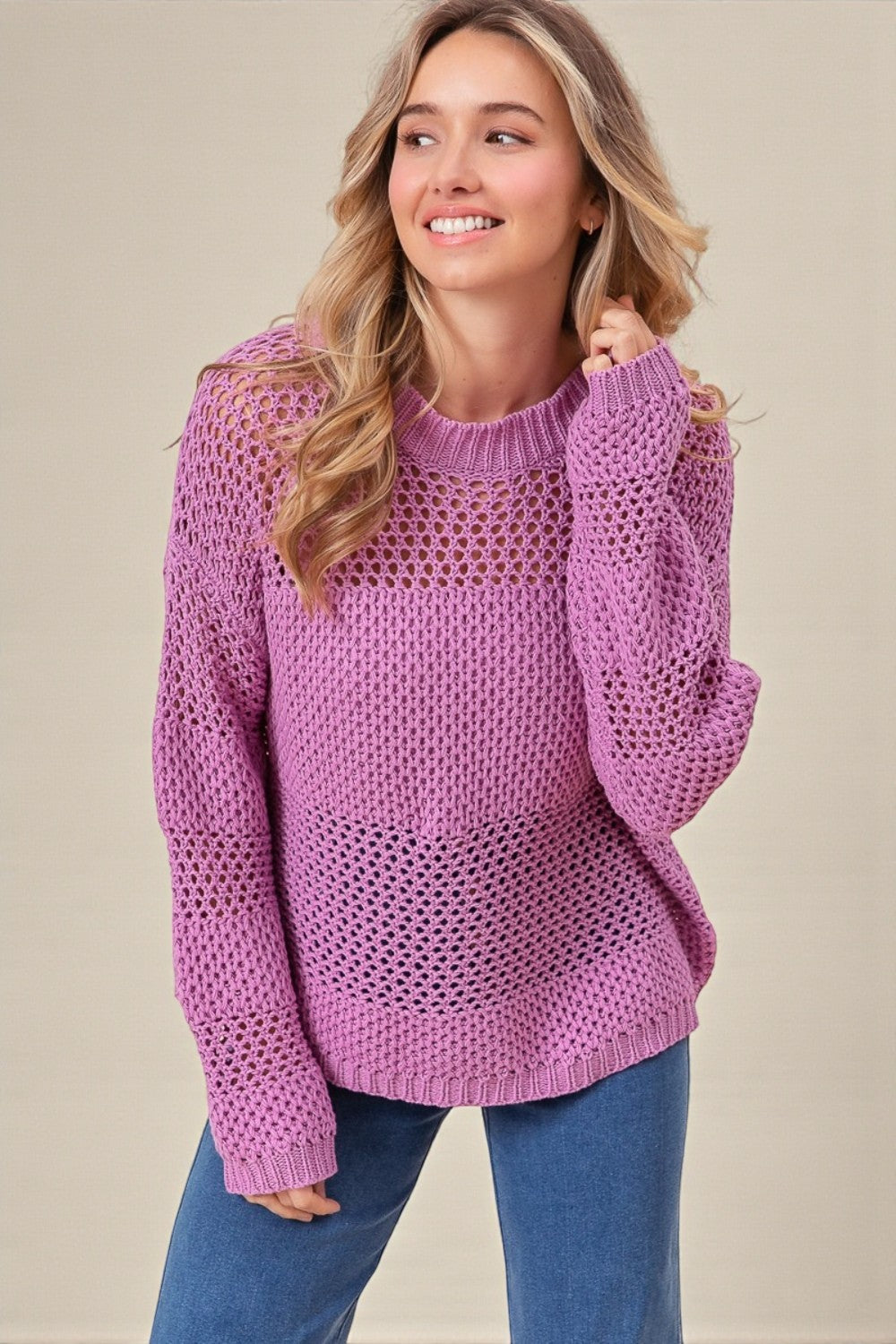 Woman wearing a purple sweater against a beige background