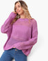 A woman wearing a lavender open-knit crewneck sweater and blue jeans, posing against a clean white background.