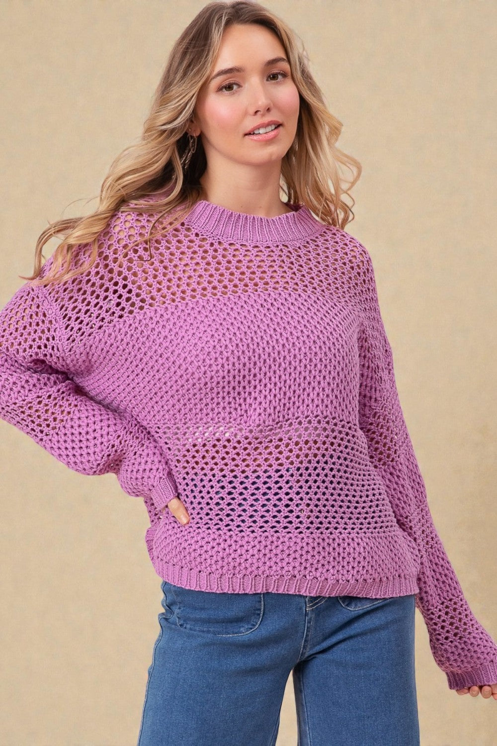 Woman wearing a purple sweater against a beige background