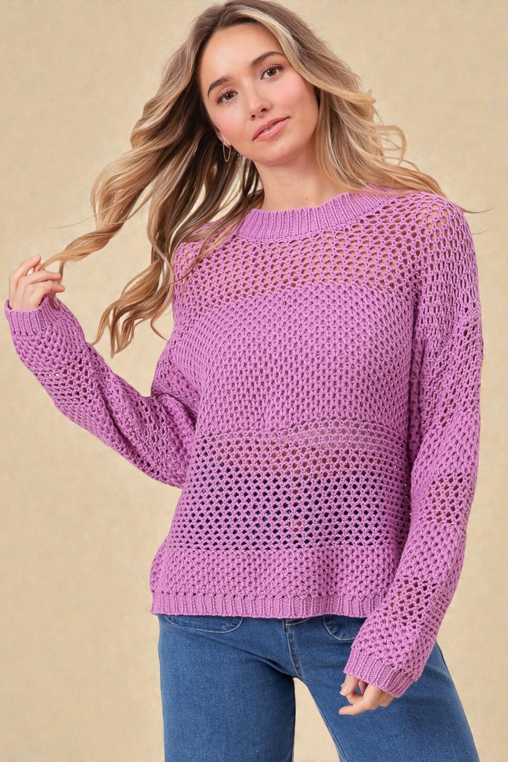 Woman wearing a purple knitted sweater against a beige background