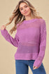 Woman wearing a purple knitted sweater against a beige background