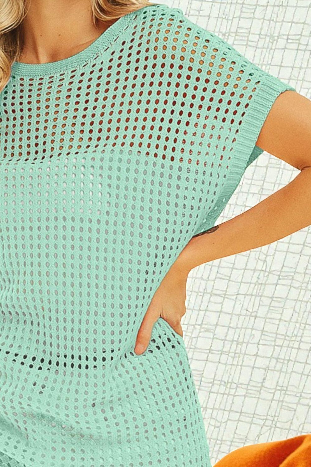 Mint green crochet top worn by a person with a white textured background