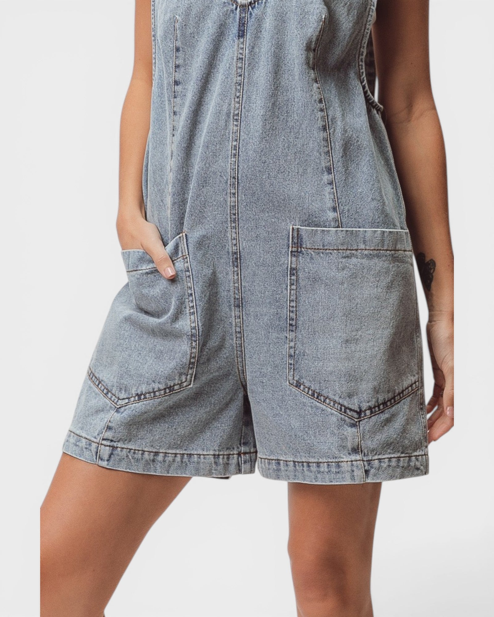 Denim dress with pockets on a plain background