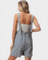 Woman wearing denim overalls on a plain background