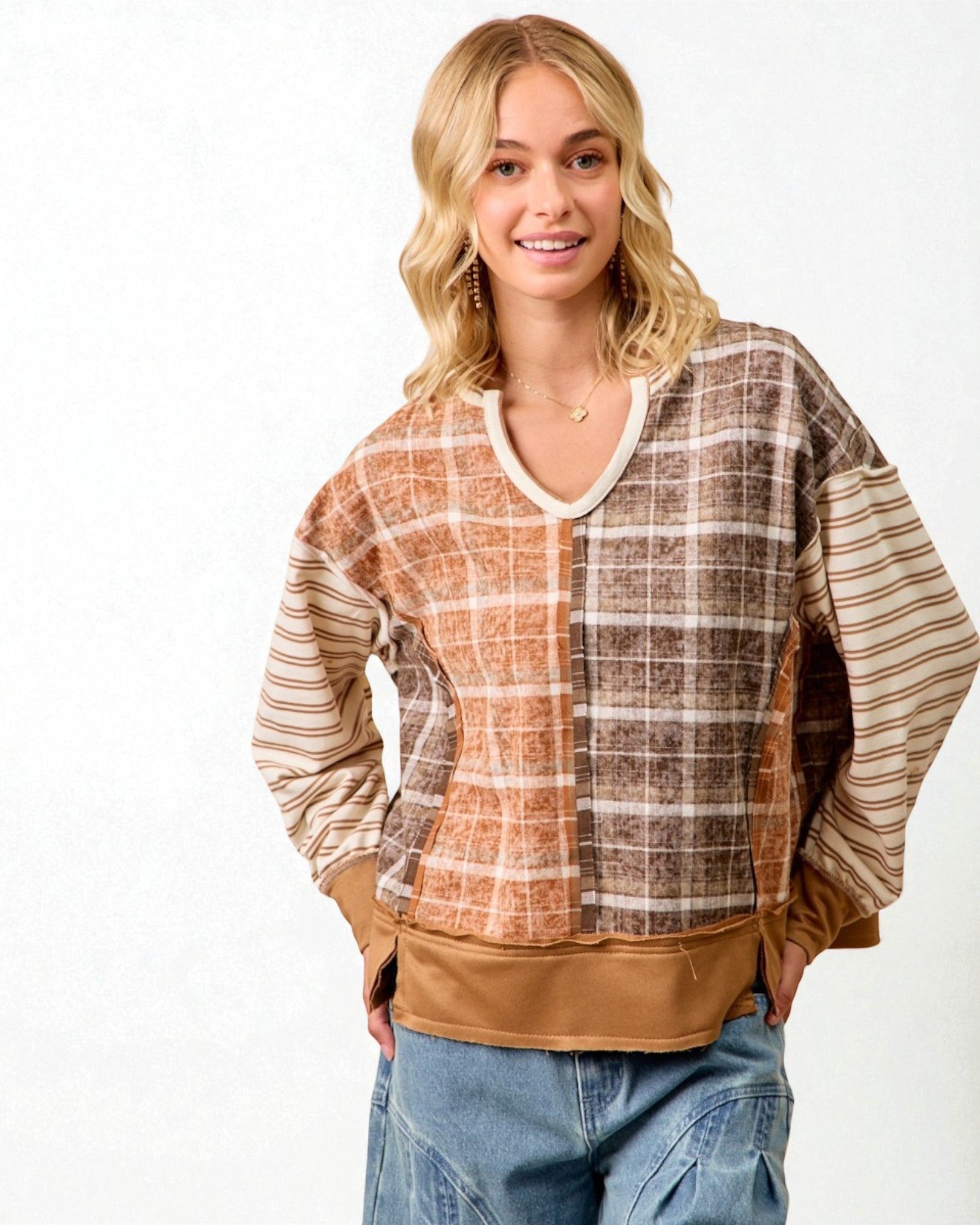Woman wearing a plaid shirt with a brown base and beige accents on a white background