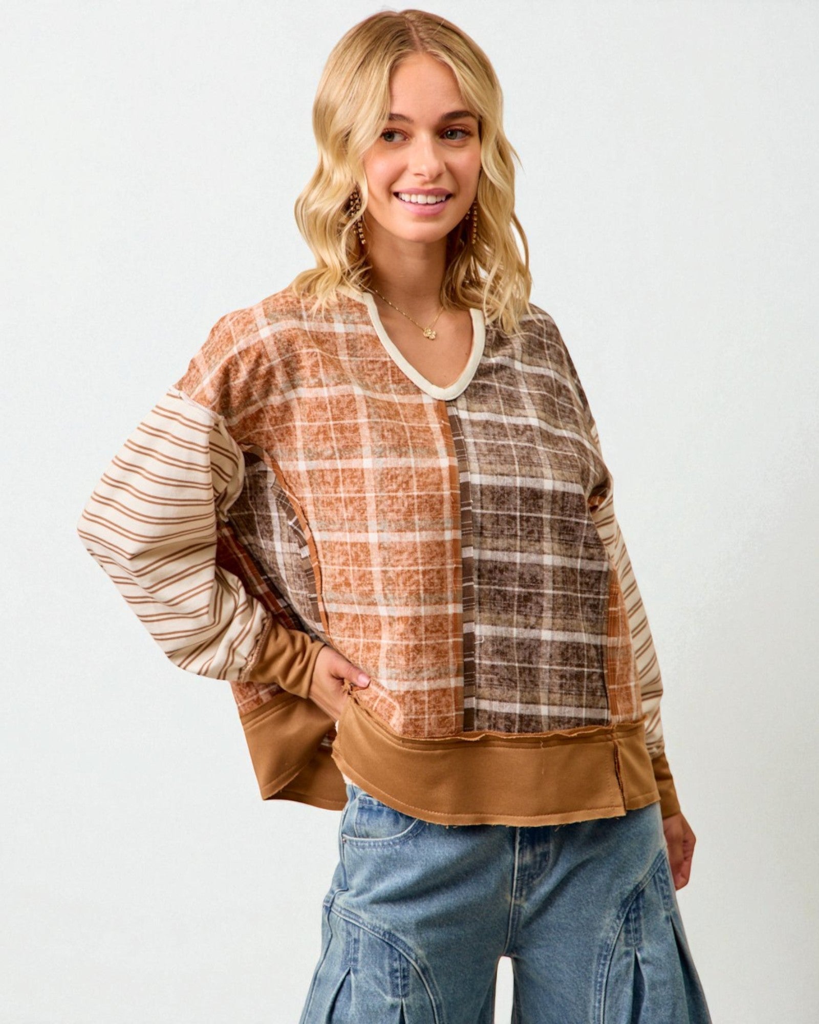 Woman wearing a plaid shirt with brown sleeves and a beige bottom half on a white background