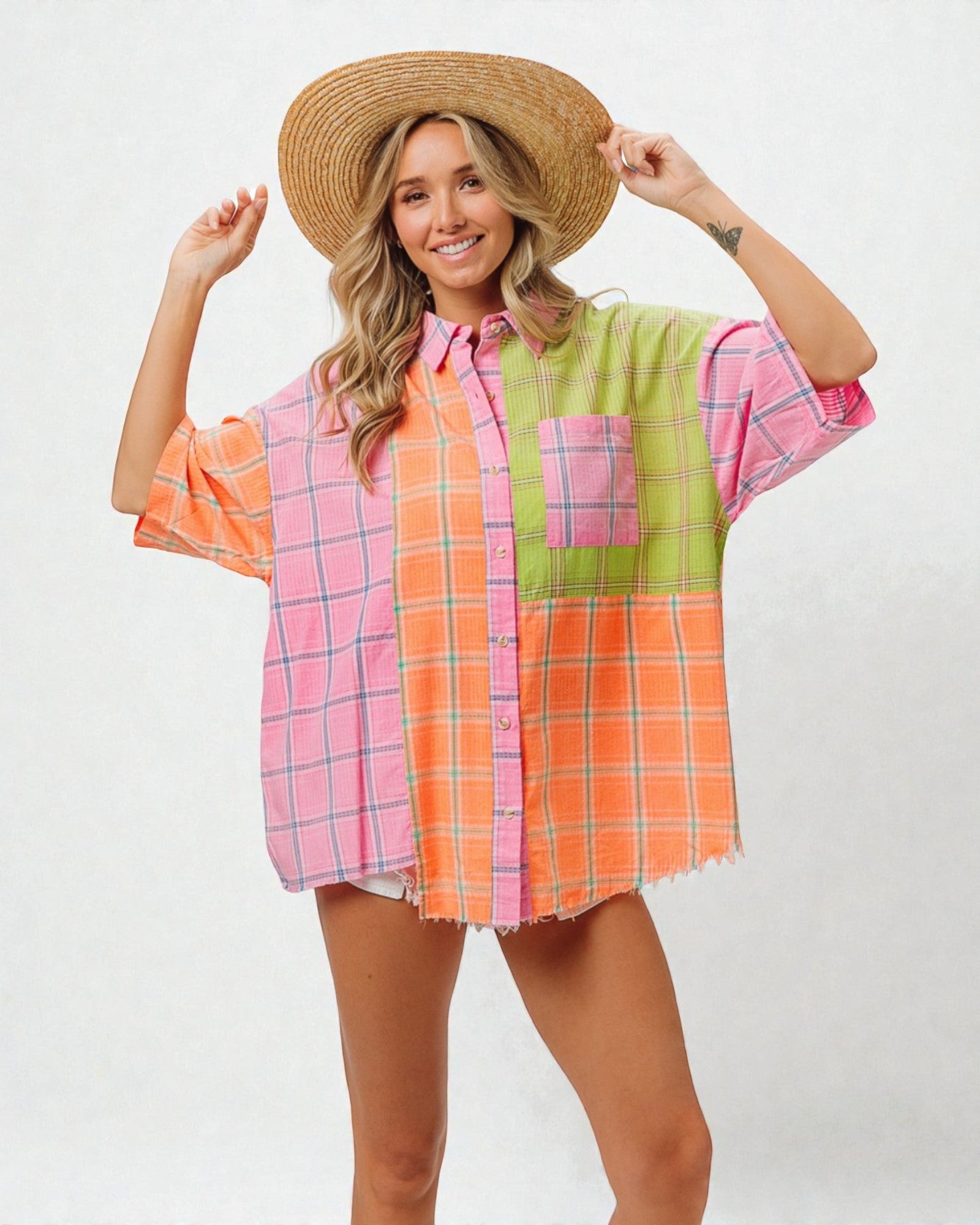 Person wearing a colorful plaid shirt and straw hat on a white background