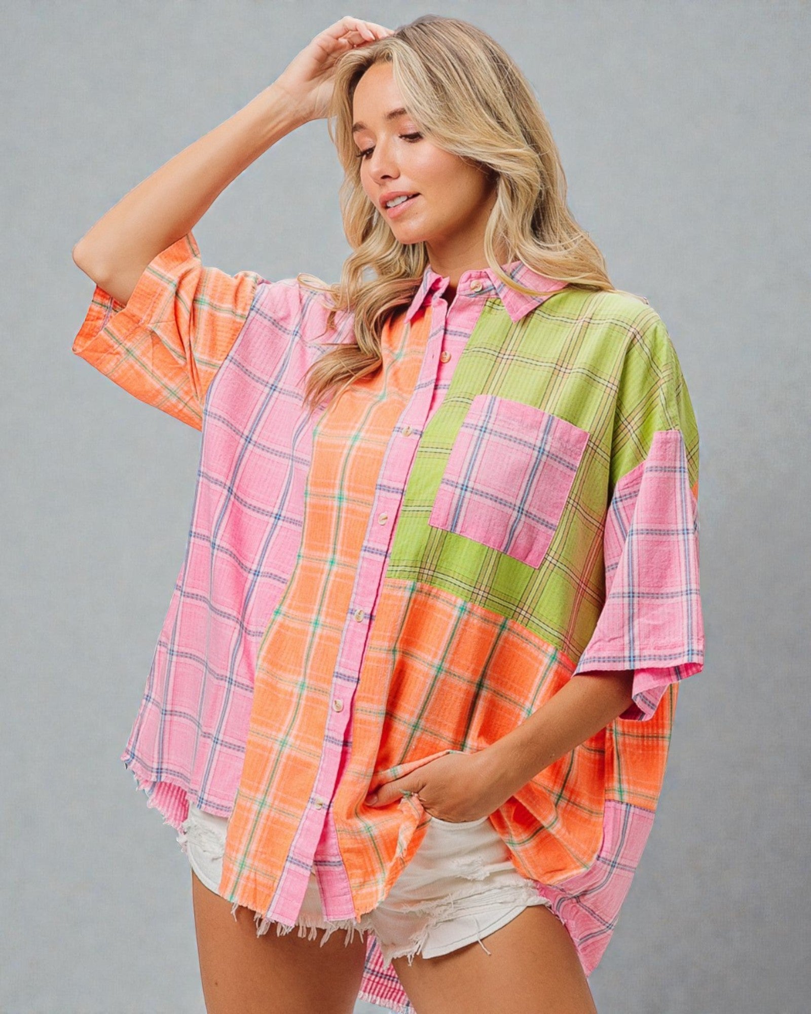 Woman wearing a colorful plaid shirt with a gray background