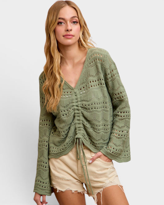 Woman wearing a green crochet sweater on a white background