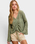 Woman wearing a green crochet sweater on a white background