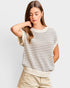Woman wearing a striped sweater and beige pants on a light gray background