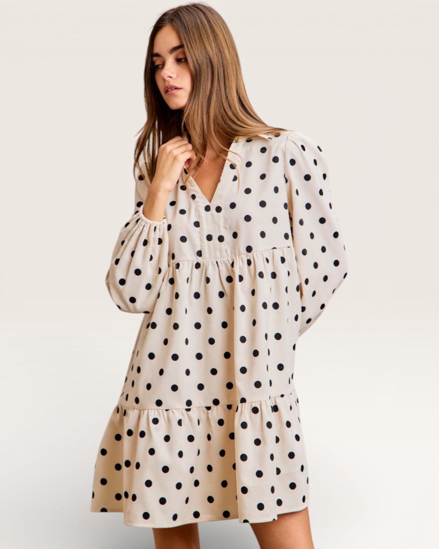 Woman wearing a polka dot dress on a plain background