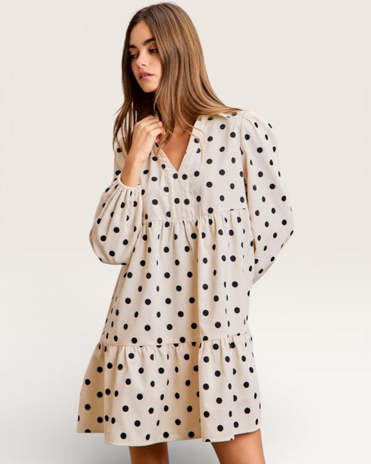 Woman wearing a polka dot dress on a plain background