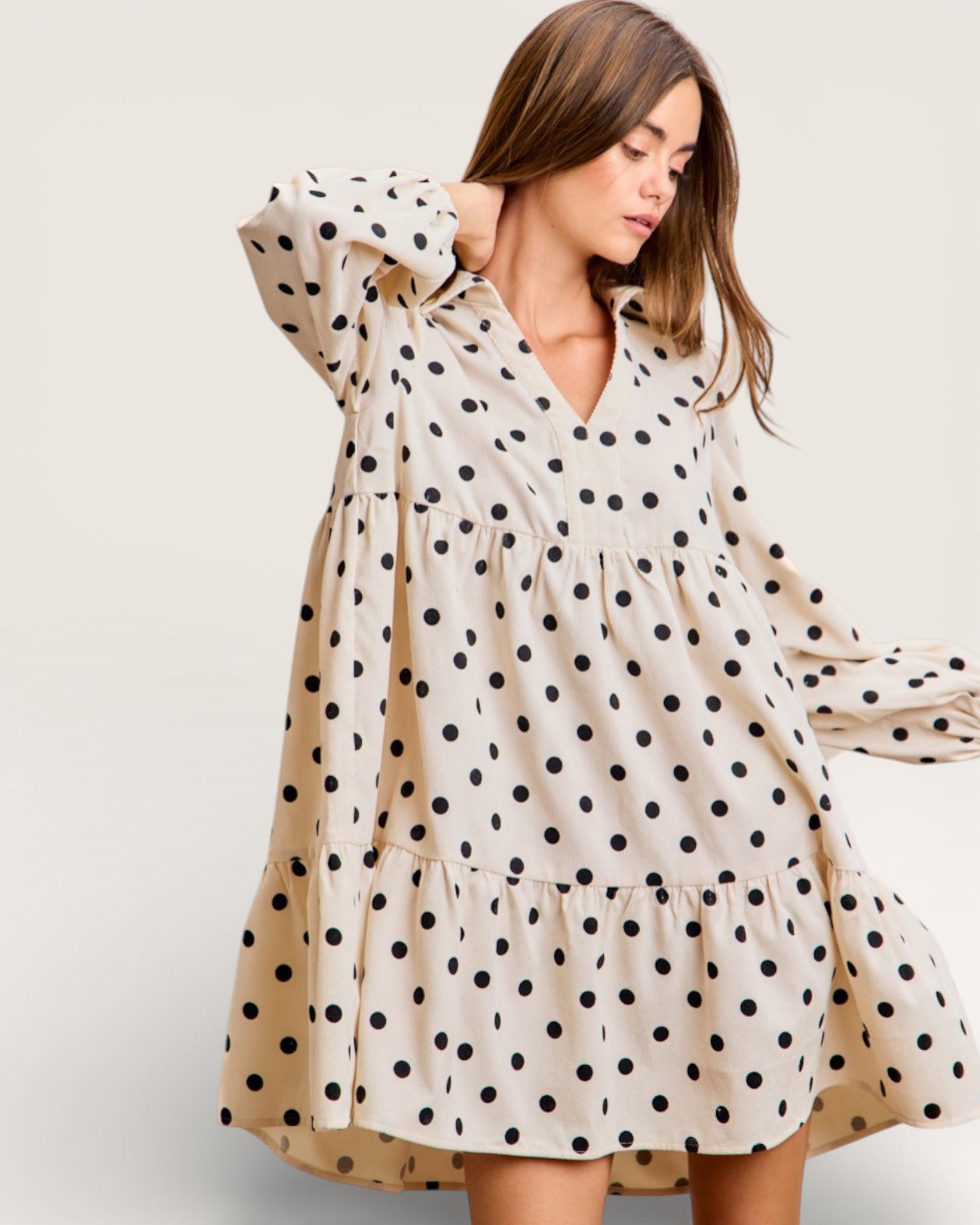 Woman wearing a polka dot dress against a plain background